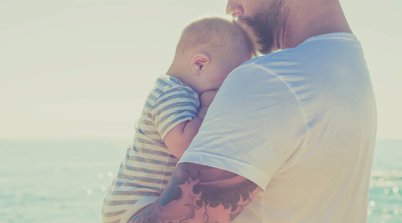 Man holding newborn baby to his chest