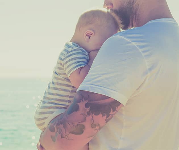 Man holding newborn baby to his chest