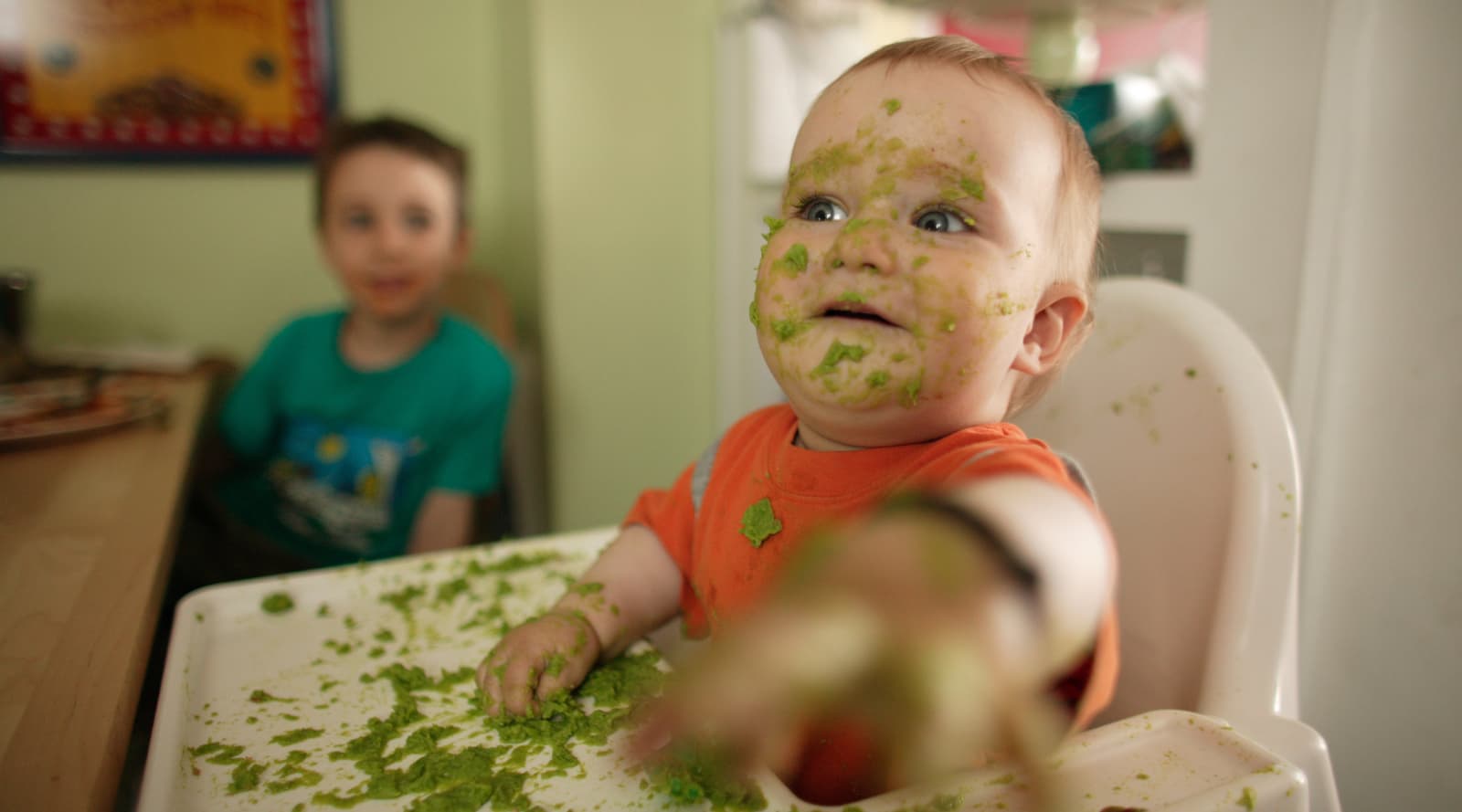 Messy baby eating on a baby chair