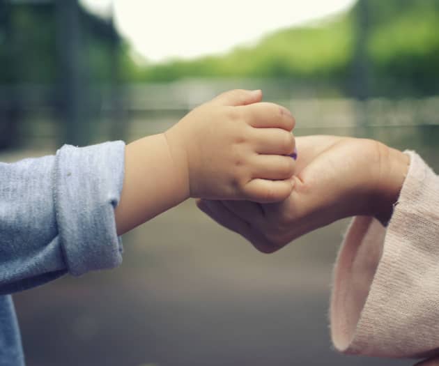 Baby holding a woman’s hand